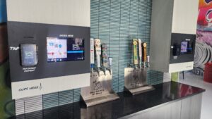 Unattended TendedBar vending wall with order-here screen, tap handles, and cups-here signage, no attendant